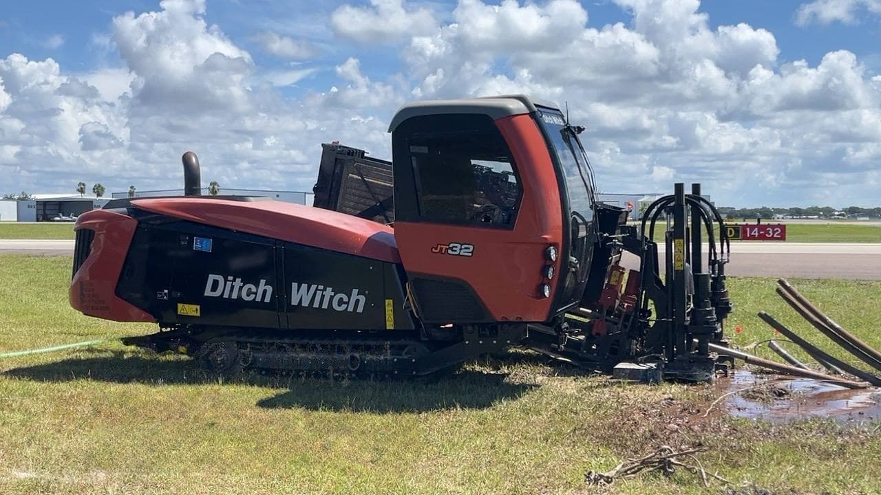 Ditch Witch JT32 directional drill with drill stems laid out on an airfield bore