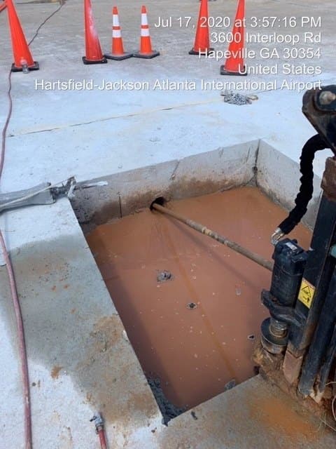 Directional drilling under a concrete walkway at an airport